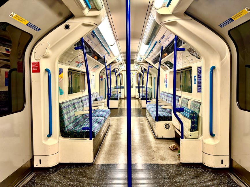 Photograph of the exterior entrance to Wembley Park Station showing a large, elevated sign displaying the station's name in bold, uppercase letters on a metal framework. Below the sign, a blue panel i